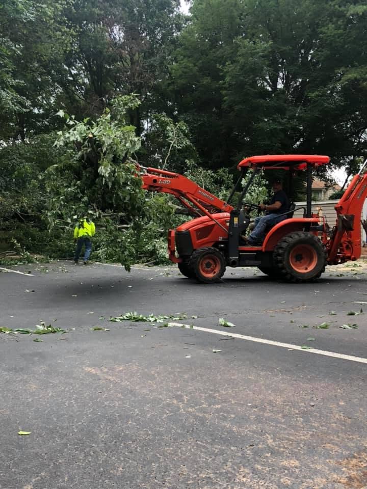Tractor clearing downed limbs from a road